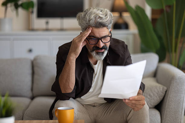 istock Upset frustrated mature man holding reading postal mail letter 2239996576
