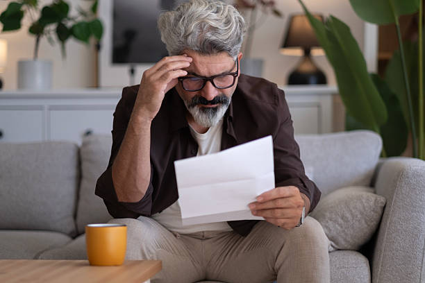 istock Upset frustrated mature man holding reading postal mail letter 2239996661