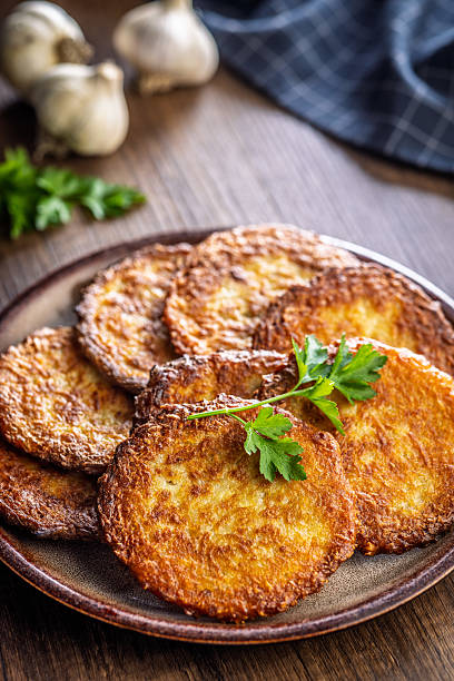 istock Fried potato pancake on plate on wooden table. 2239999405