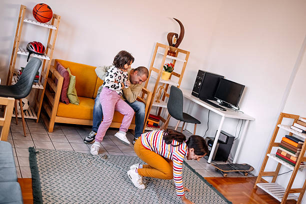 istock Young girls at home having fun spending time with father while using body paint for drawing on faces 2240001748