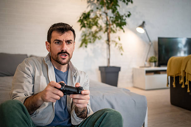 istock Man playing video games with focused intensity 2240001873