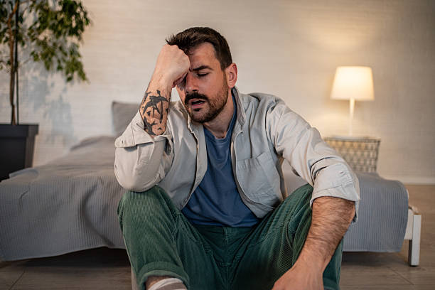 istock Man feeling overwhelmed and stressed sitting on floor 2240001927