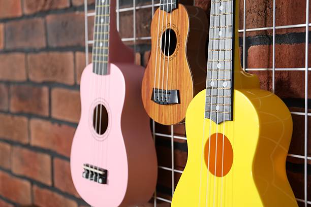 istock Three colorful ukulele on brick wall indoors, closeup 2240002548