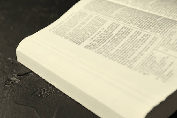 Open Bible on a black background. Religion concept. High quality photo. Space for text. Bible book close-up. Bible pages close-up.