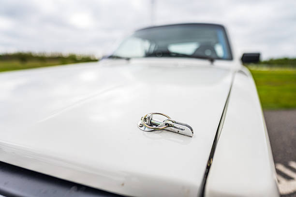 Volvo hood pin fastener on white body.