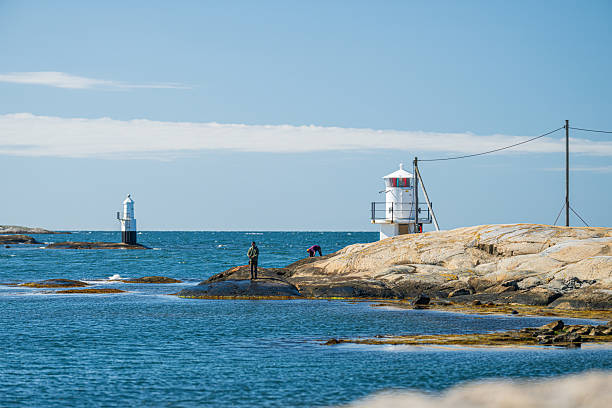 istock Twin coastal lighthouses on rocky shoreline landscape.. 2240003789