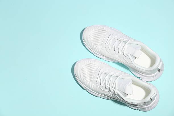 istock Pair of stylish white sneakers on light blue background, top view. Space for text 2240005483