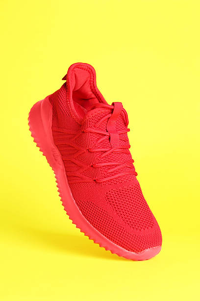 istock Stylish red sneaker in air against yellow background 2240005609