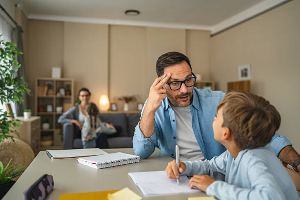 istock Father helping son with homework at home learning together 2240005620