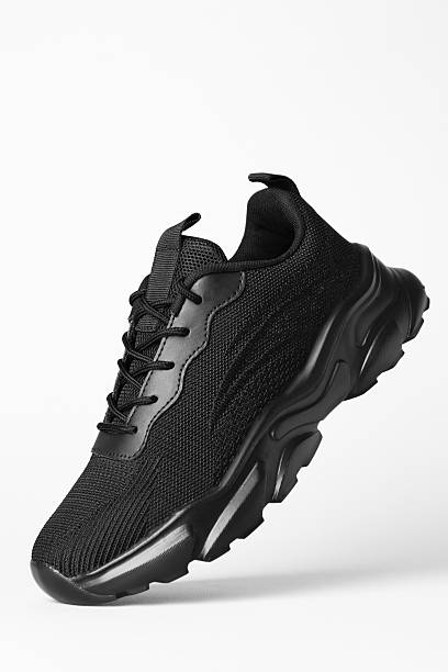 istock Stylish black sneaker in air against white background 2240005649