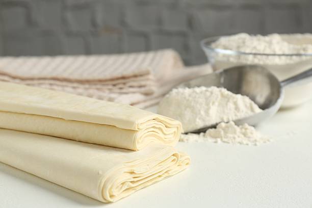 istock Raw puff pastry dough on white table, closeup. Space for text 2240006120