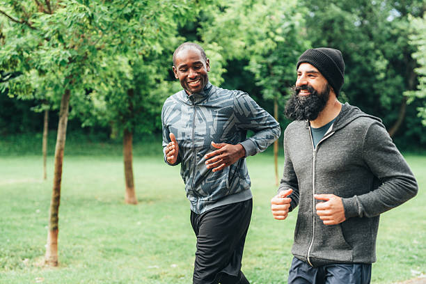 istock Cardio training outdoors. Happy athletes having fun while running together in nature. 2240013836