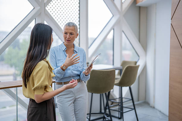 istock Businesswomen discussing work in modern office with digital tablet 2240020852