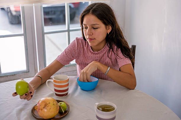 istock Young woman enjoying healthy breakfast with fresh fruit 2240021098