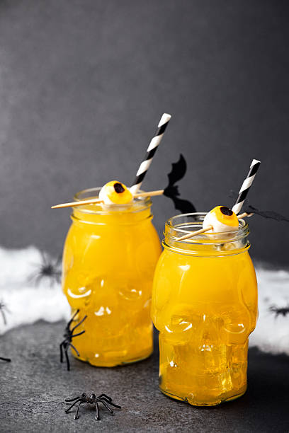 istock Spooky Halloween drinks in skull jars with spooky eyeballs and spiders on dark background 2240021162