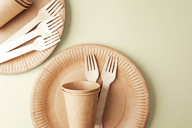 istock Sustainable tableware with eco paper cups and forks on green background minimalist concept 2240021191