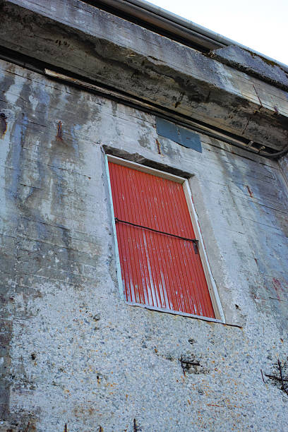 istock Rustic red wooden shutters on an aged concrete wall in Scandinavian architecture 2240025519