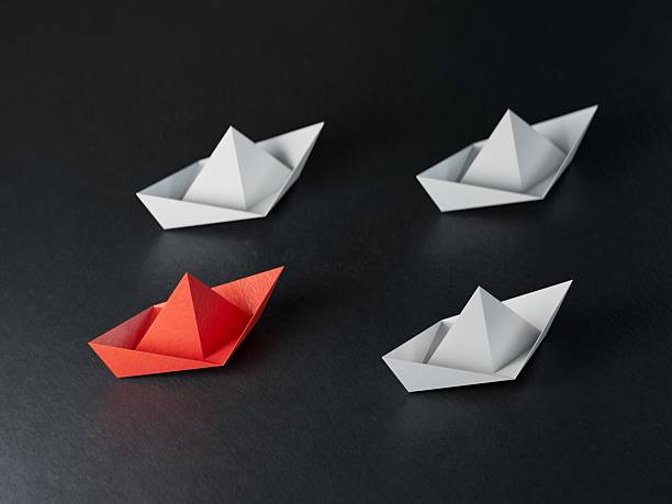 istock New ideas creativity and different innovative solution. Business concept. A group of paper ships, one boat is flying in the other direction, different way. 2240028416