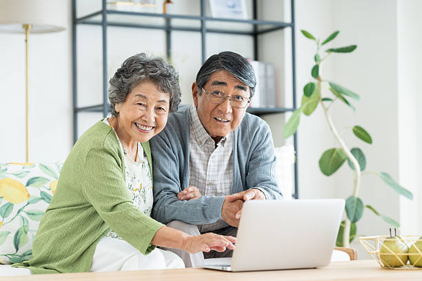 istock Senior couple using a computer in the living room 2240031837