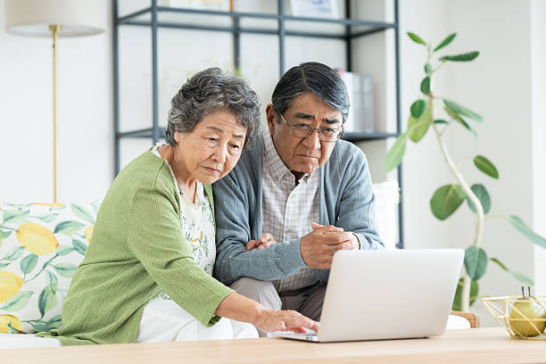 istock Senior couple using a computer in the living room 2240031839