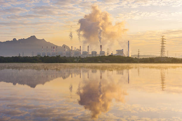 istock Dramatic Mae Mo Power Plant at Twilight, Lampang, Thailand. Coal-fired power station with steam smoke and fog reflecting on the lake water. Emphasizing industry, energy, and environmental impact in Northern Thailand. 2240035332