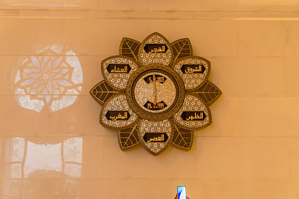 Muslim prayer clock inside Sheikh Zayed Grand Mosque in Abu Dhabi, UAE, marking daily Islam prayers central to Islamic religious life.