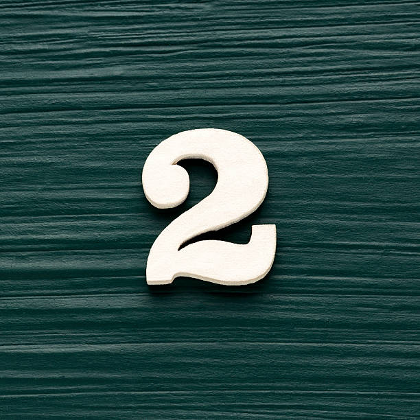 istock Number 2 white piece on a rustic dark green background 2240036372