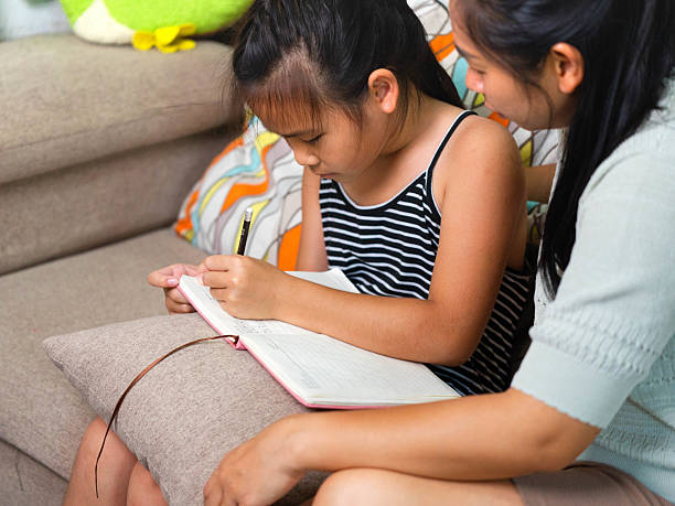 istock Asian Mother Teaching Her Daughter to Write at Home 2240039819