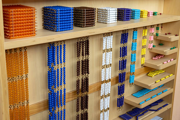 istock Development of mathematical skills according to the Montessori method. Multicolored cubes and beads on a shelf for alternative for studying mathematics in elementary or primary school 2240040809