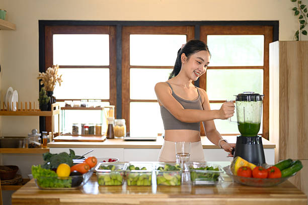 istock Young woman in activewear preparing a fresh vegetable smoothie for a balanced diet 2240043760