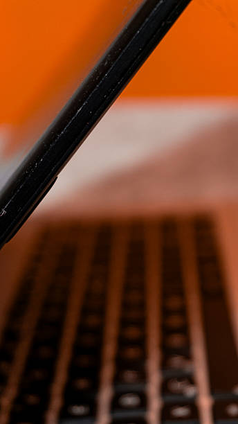 istock Open laptop on desk with vibrant orange background, modern workspace concept highlighting creativity, technology, and digital lifestyle. 2240043793