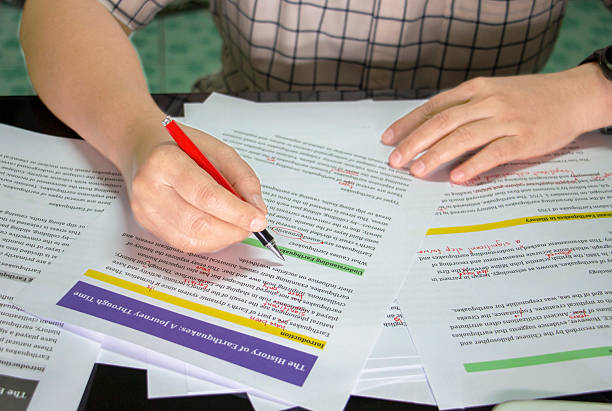 istock hand holding red pen to do proofreading 2240044707