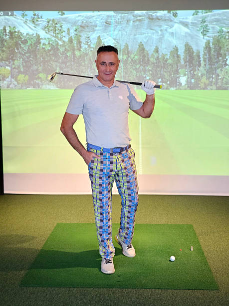 istock Golf enthusiast stands confidently with a club indoors, enjoying virtual driving range 2240051768