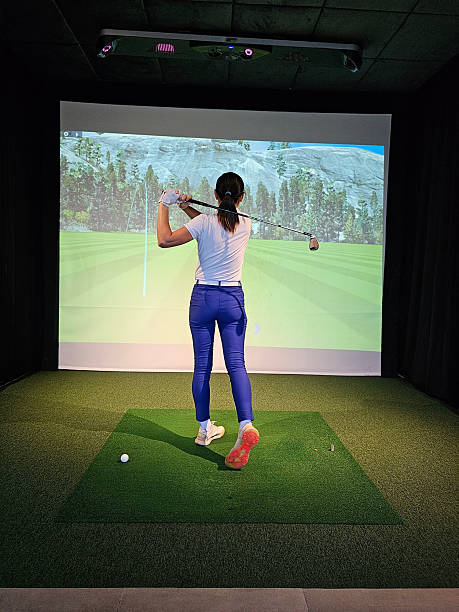istock Woman practicing golf swing indoors at a virtual simulator with projected scenery in background 2240052267