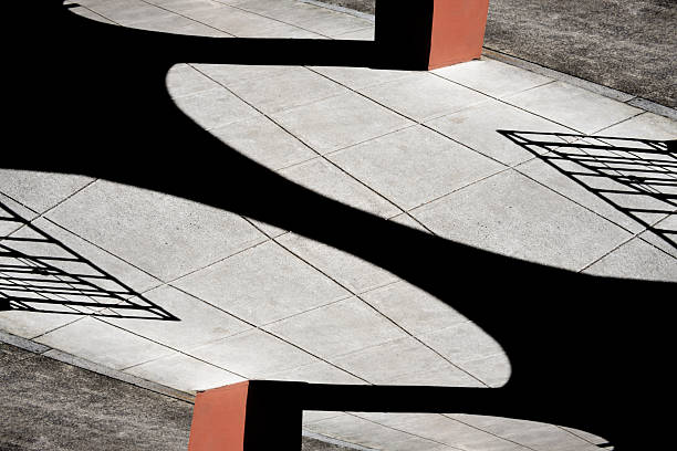 Abstract background of high contrast sunlight and shadows on a concrete floor.