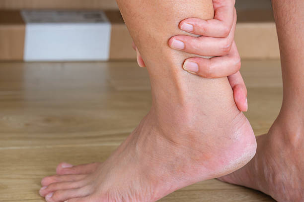 istock Man gripping aching Achilles tendon—ankle pain while walking. 2240054016