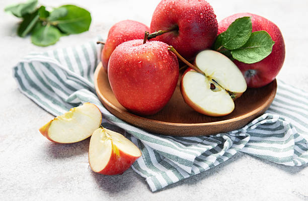 istock Fresh red apples in wooden bowl with slices 2240054731