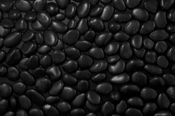 istock Black pebbles for texture background. Shining smooth natural black stones 2240055057