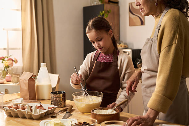 istock Girl Baking with Middle Aged Woman in Kitchen Preparing Batter 2240056225