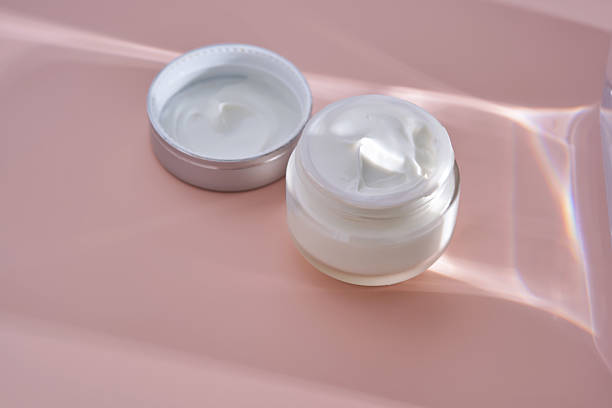 istock An open jar of cream with its texture on a pink background. 2240056298