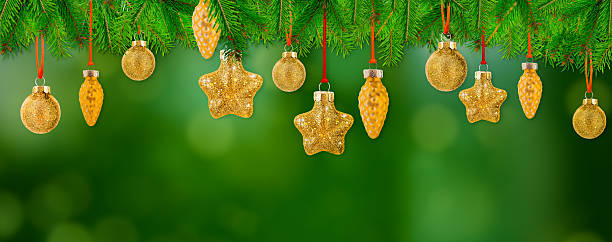 Festive background featuring fir branches decorated with golden baubles, stars, and pine cone ornaments on a vibrant green backdrop — perfect for holiday banners, web headers, or greeting card designs.