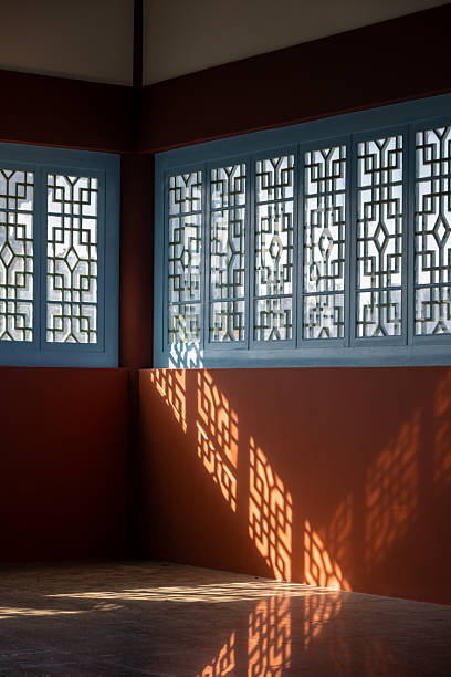 istock Traditional Chinese Lattice Window Casting Intricate Shadows on the Wall 2240057660
