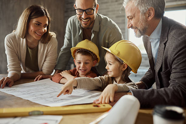 istock Happy family and their architect reading blueprints during home renovation process. 2240058006