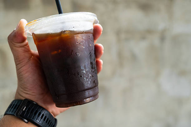 istock The hand holding a cold black coffee 2240058493