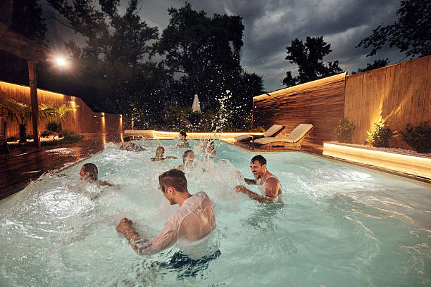 istock Cheerful friends having fun during night party in the pool. 2240059859