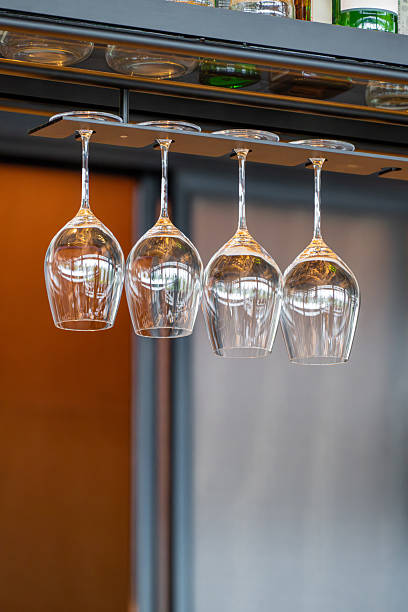 Elegant Wine Glasses Hanging Upside Down from a Bar Rack in a Modern Kitchen Setting