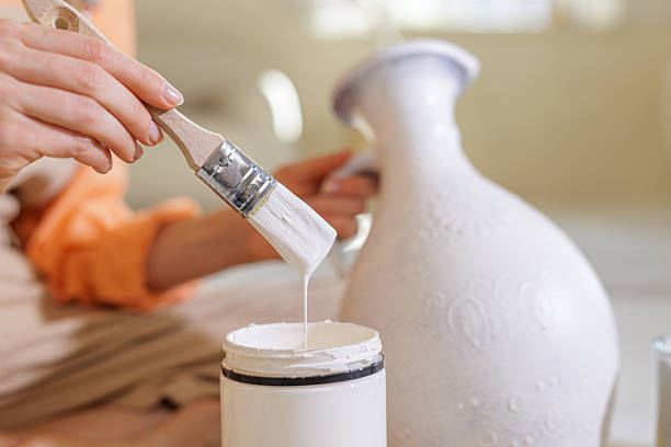 istock Closeup brush dripping white paint for DIY vase upcycling and home decor 2240061112