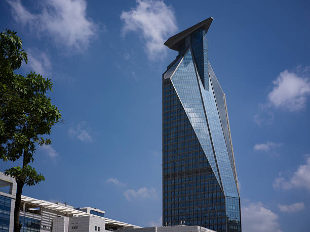 istock A striking modern skyscraper with a unique architectural design stands tall against a clear blue sky with scattered white clouds 2240062881