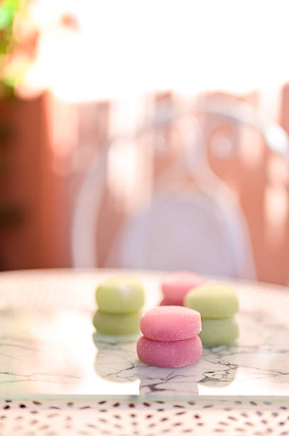 Pastel mochi desserts on a marble table with soft bokeh