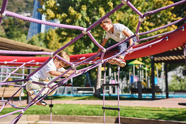 istock Two boys climbing on a rope structure at the playground 2240063128
